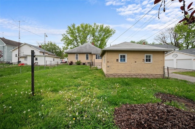 back of property featuring fence and a lawn