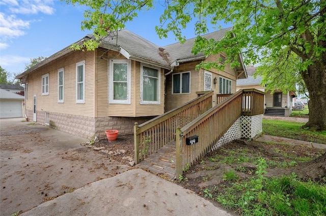 view of front of home featuring an outbuilding, driveway, and stairs