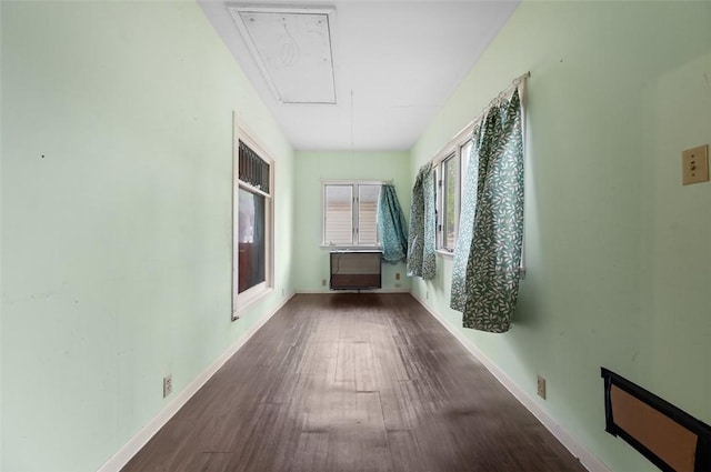hallway with attic access, wood finished floors, and baseboards