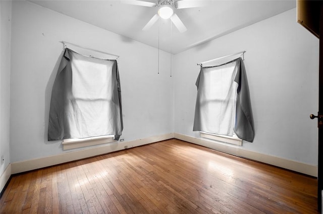 unfurnished room featuring ceiling fan, baseboards, and hardwood / wood-style floors