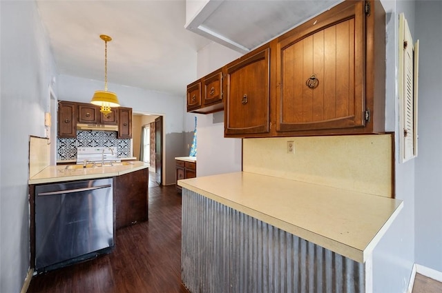 kitchen featuring under cabinet range hood, stainless steel dishwasher, dark wood-style flooring, decorative backsplash, and light countertops
