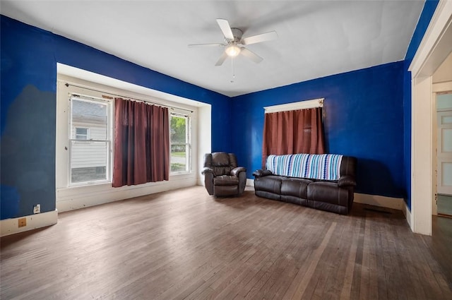 sitting room featuring baseboards, a ceiling fan, and wood-type flooring