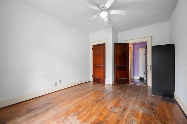 unfurnished bedroom with baseboards, hardwood / wood-style floors, and a ceiling fan