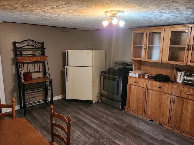 kitchen with brown cabinetry, stainless steel electric stove, dark wood-style floors, and freestanding refrigerator