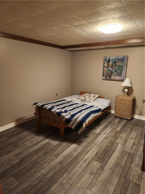 bedroom featuring baseboards and wood finished floors