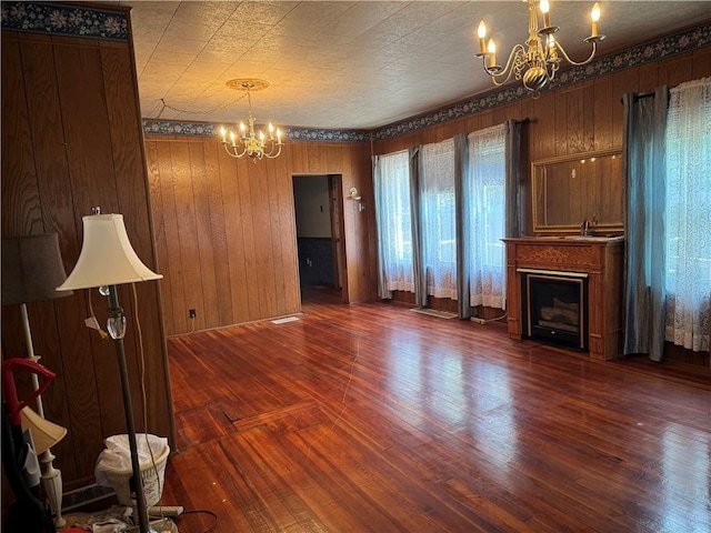1524 Adams Ave, Charleston, IL 61920 - unfurnished living room featuring a chandelier, wood finished floors, a fireplace, and wood walls
