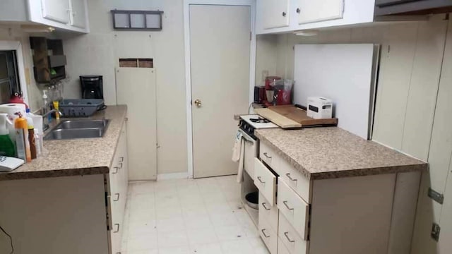 221 Celebration Ct, Oakwood, IL 61858 - kitchen featuring gas range gas stove, white cabinetry, light countertops, and light floors