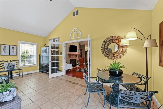 707 W Coolidge Ave, Charleston, IL 61920 - dining area with high vaulted ceiling, a fireplace, and tile patterned flooring