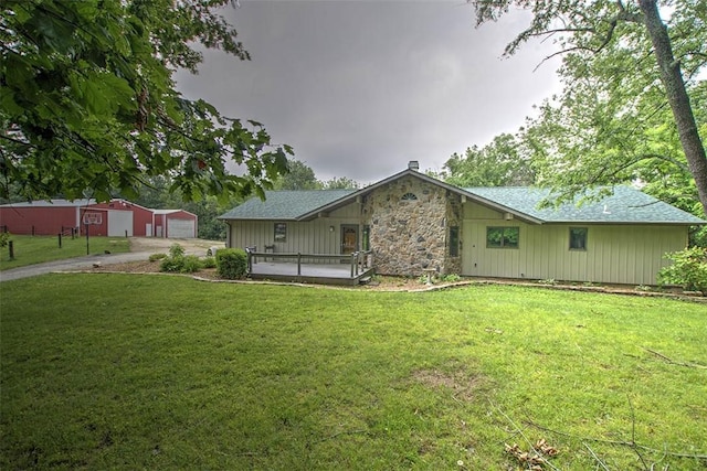 5959 Heritage Ln, Oakley, IL 62501 - view of front facade featuring a front lawn, an outbuilding, stone siding, and driveway
