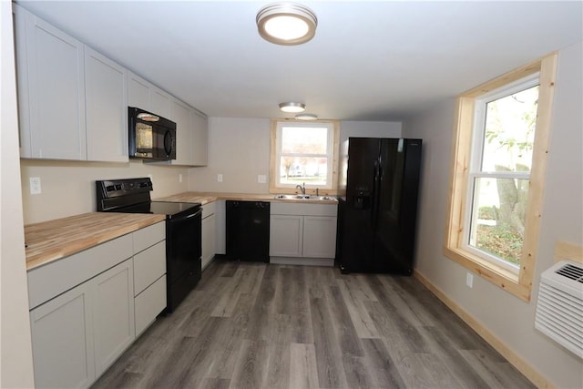2805 Commercial Ave, Mattoon, IL 61938 - kitchen with black appliances, light wood-style flooring, butcher block countertops, and white cabinetry