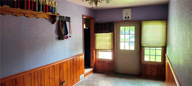 doorway to outside featuring wooden walls