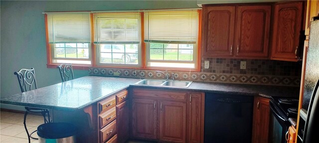 kitchen featuring black appliances, decorative backsplash, sink, and a wealth of natural light