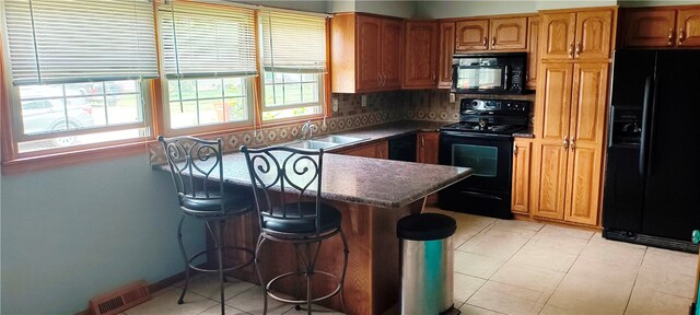 kitchen with backsplash, a wealth of natural light, sink, and black appliances