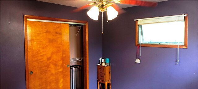 unfurnished bedroom featuring ceiling fan and a closet