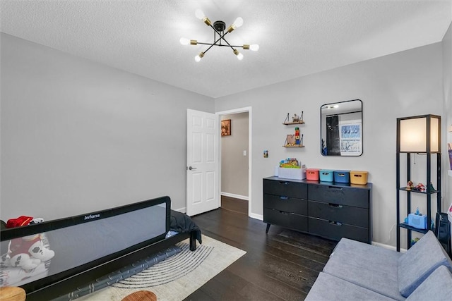 bedroom with baseboards, a textured ceiling, a chandelier, and wood finished floors