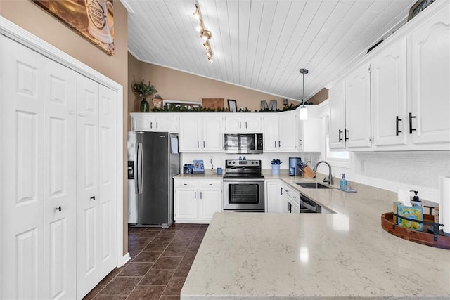 kitchen featuring light stone countertops, vaulted ceiling, stainless steel appliances, white cabinetry, and a sink