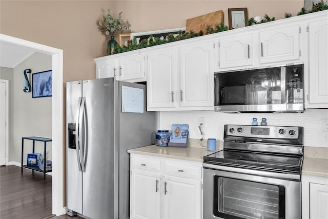 kitchen with white cabinetry, stainless steel appliances, backsplash, and light countertops