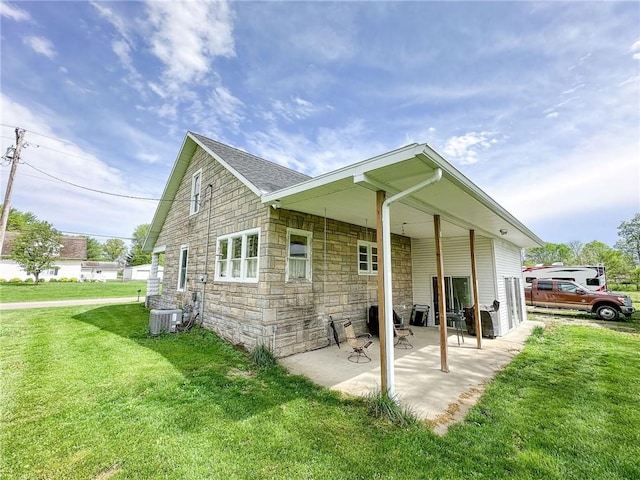 1625 Archer Ave, Marshall, IL 62441 - back of property with cooling unit, a yard, a patio area, and stone siding