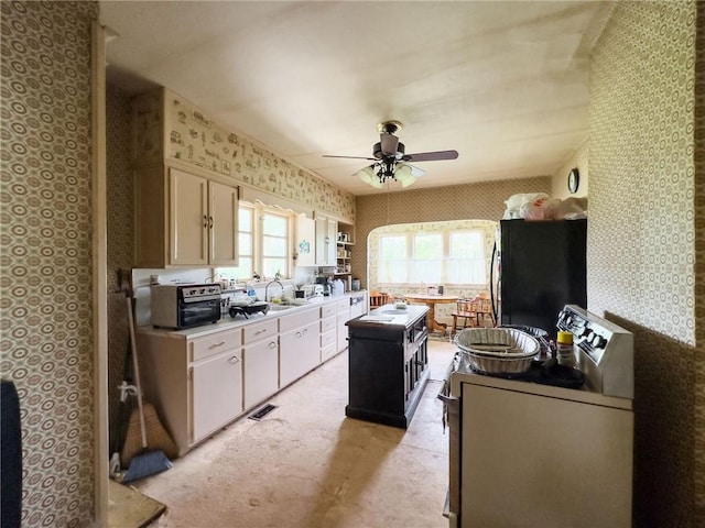 1625 Archer Ave, Marshall, IL 62441 - kitchen featuring light countertops, stove, freestanding refrigerator, a ceiling fan, and wallpapered walls