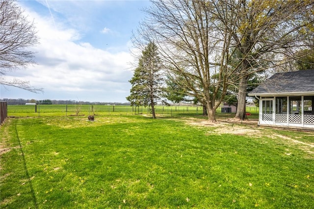 view of yard with fence and a sunroom