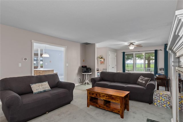 living area featuring light carpet and a ceiling fan