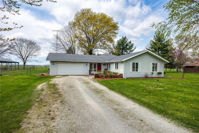 ranch-style home featuring an attached garage, fence, driveway, and a front yard