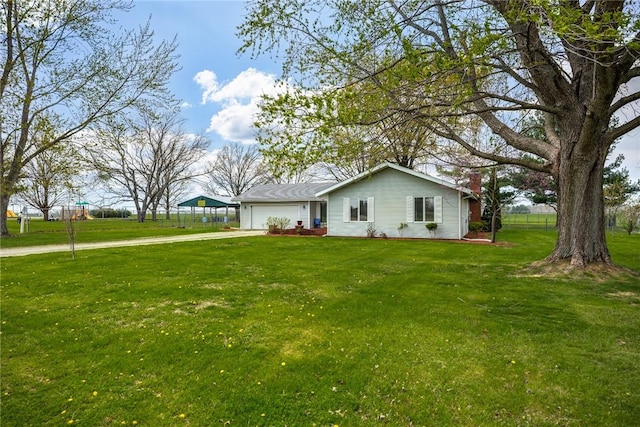 exterior space featuring a lawn, fence, an attached garage, and concrete driveway