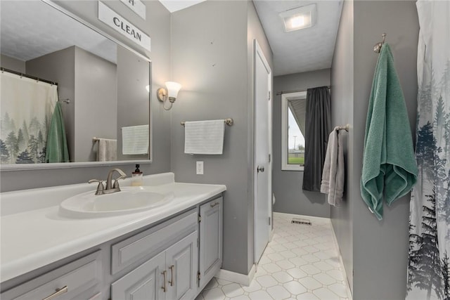 bathroom featuring vanity, baseboards, tile patterned floors, and visible vents
