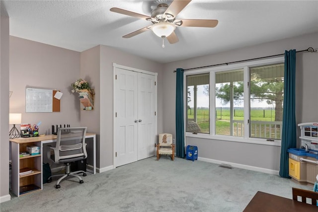 office space with baseboards, ceiling fan, and carpet