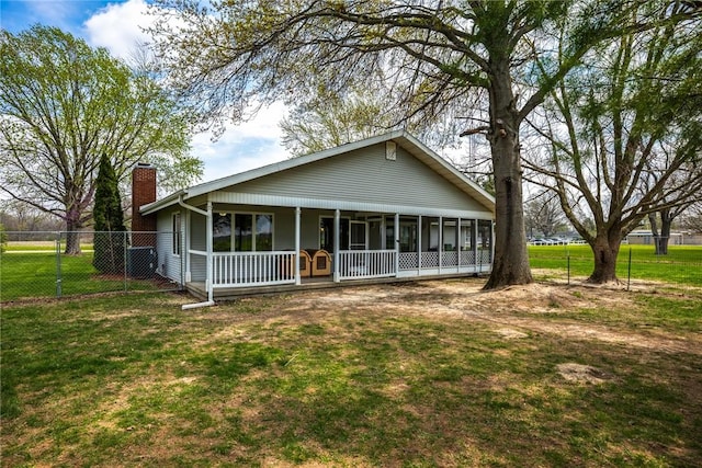 view of front facade featuring a porch, fence, a chimney, and a front yard