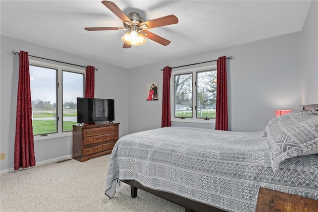 bedroom with baseboards, carpet floors, visible vents, and ceiling fan