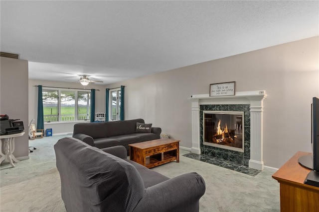 living area featuring ceiling fan, carpet floors, baseboards, a high end fireplace, and visible vents