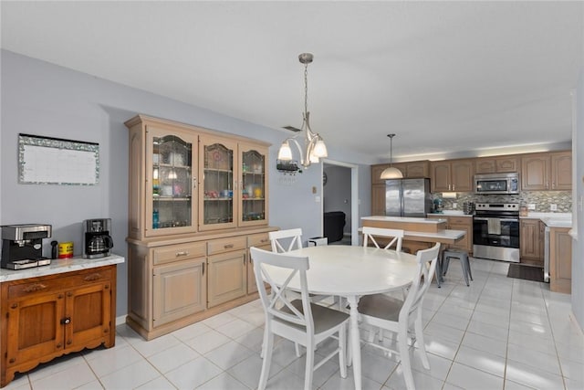 dining space featuring light tile patterned floors and a chandelier