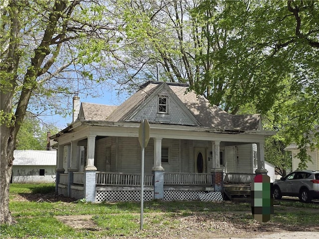 country-style home featuring covered porch and a chimney