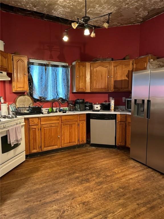 202 S College St, Blue Mound, IL 62513 - kitchen with light countertops, brown cabinetry, stainless steel appliances, and dark wood-style flooring