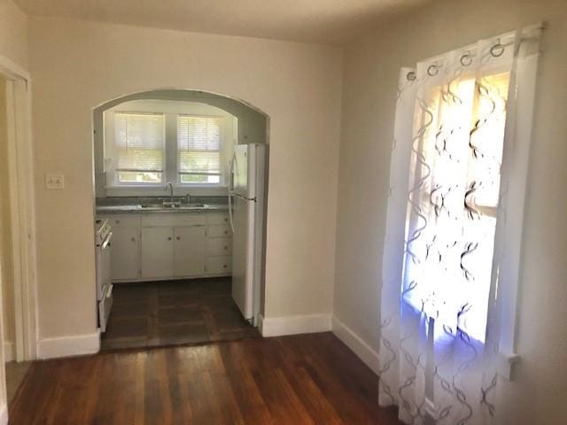 906 S 3rd St, Effingham, IL 62401 - unfurnished dining area featuring dark wood-type flooring and arched walkways