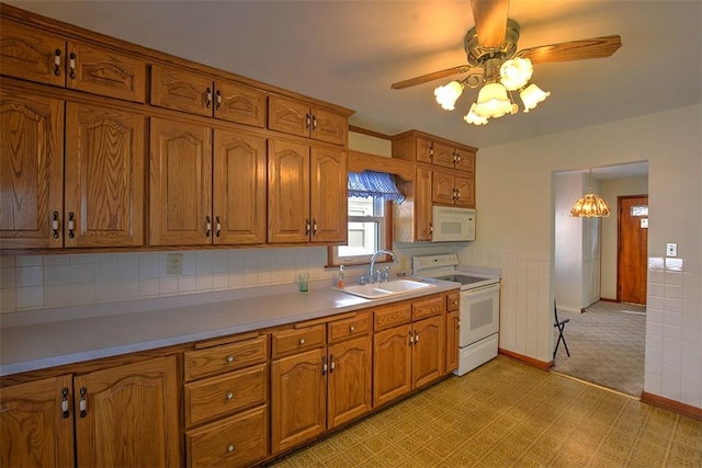 kitchen featuring ceiling fan, sink, pendant lighting, and white appliances