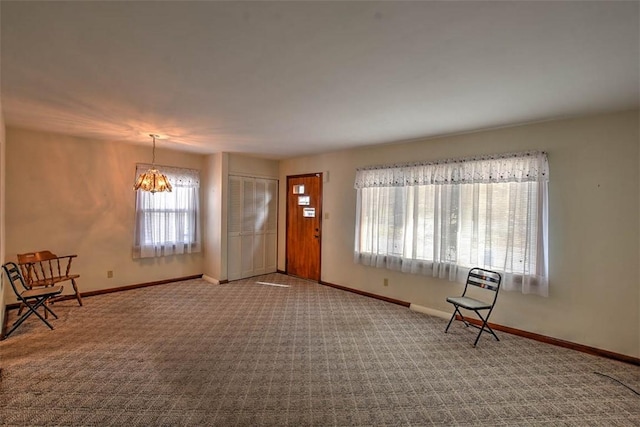 carpeted foyer entrance with an inviting chandelier