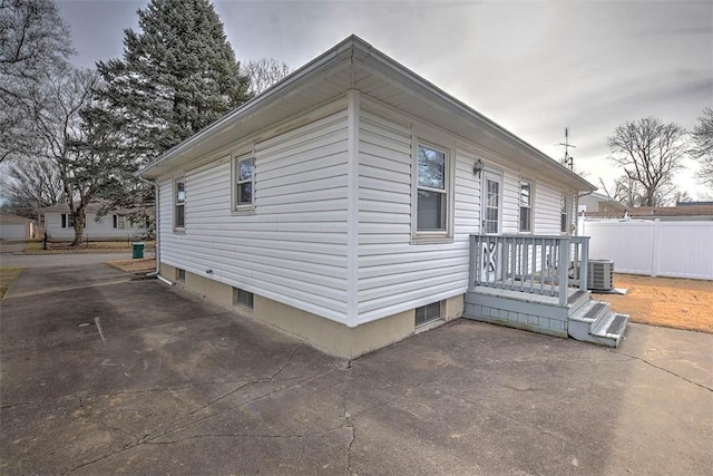 view of side of property with cooling unit and a patio area