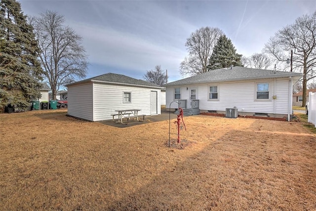 rear view of house with cooling unit and a yard