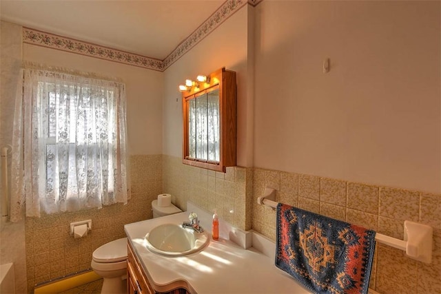 bathroom featuring vanity, toilet, and tile walls