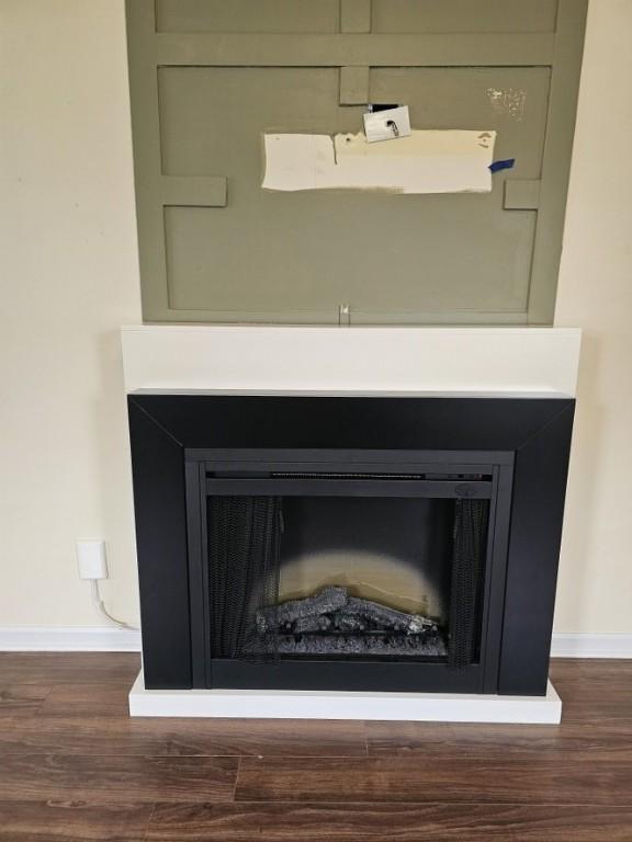 interior details with baseboards, wood finished floors, and a fireplace