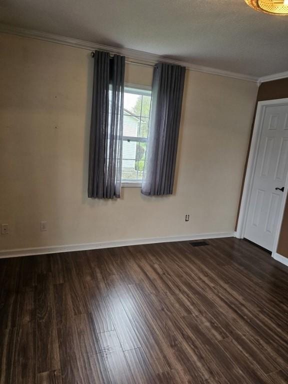 unfurnished room with baseboards, wood finished floors, and crown molding