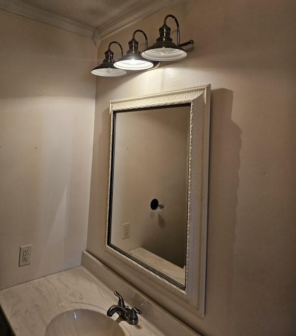bathroom with vanity and ornamental molding
