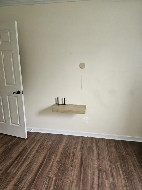 unfurnished room featuring dark wood finished floors and baseboards