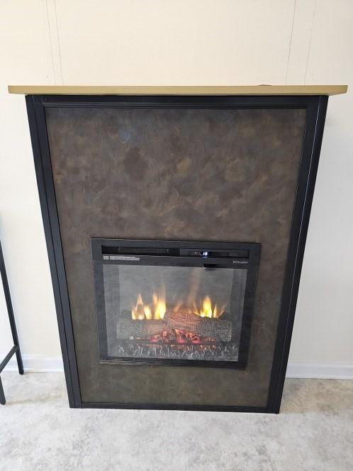 interior details with baseboards and a glass covered fireplace