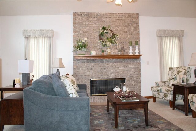 carpeted living room with a brick fireplace