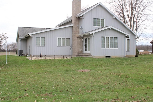 rear view of house featuring a lawn, a chimney, cooling unit, and entry steps