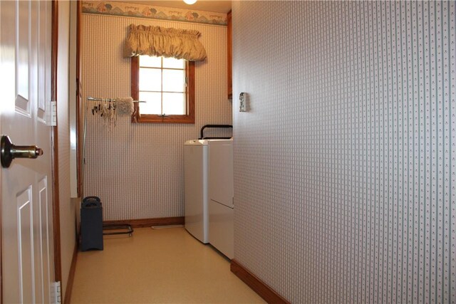washroom featuring baseboards, wallpapered walls, laundry area, and washer / dryer