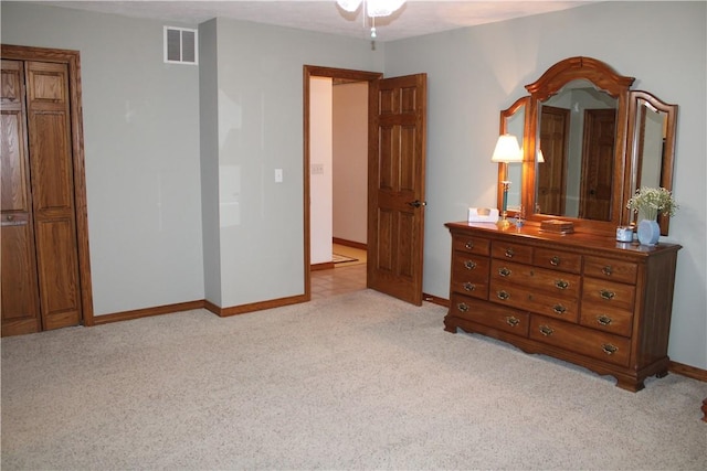 bedroom with baseboards, visible vents, and light carpet